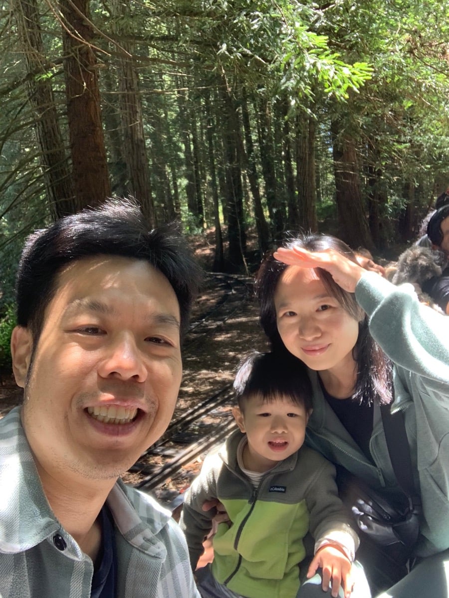 Fiona & Daniel with their family in a sun-dappled forest setting